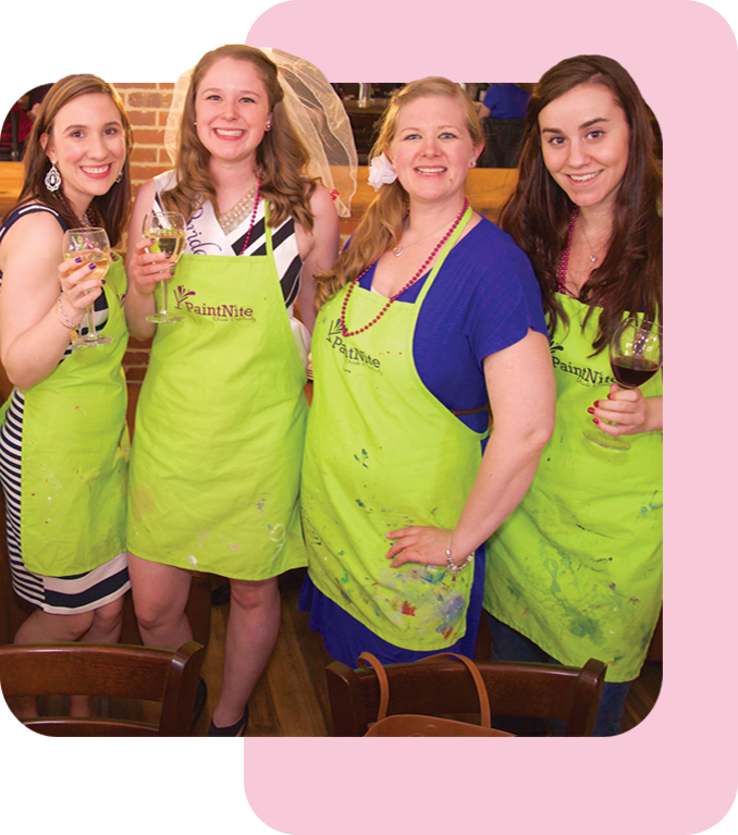 Four women in PaintNite.com aprons with wine